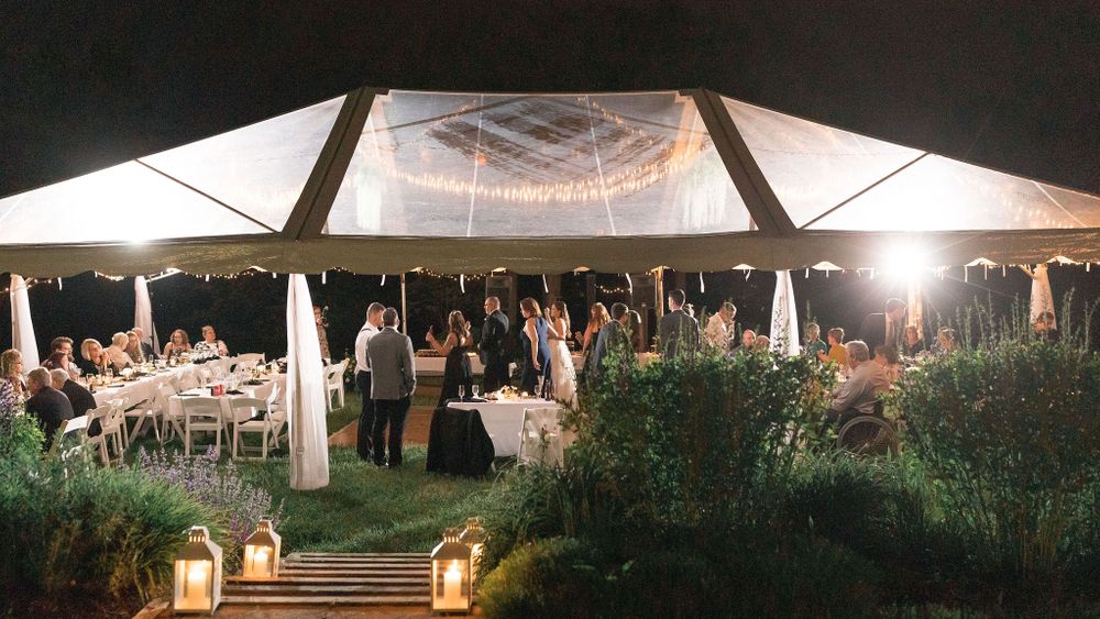 Nicely illuminated clear tent on the tent lawn. (Lindsey Rickards Photography) - Please note that the Garden Marquee is now in this area and tents are no longer needed.