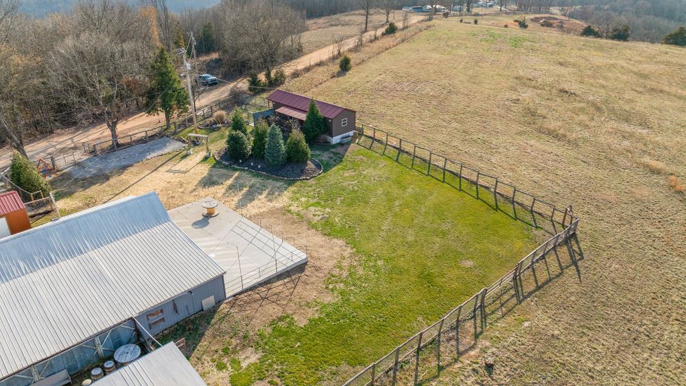 Explore the expansive grounds of Cricket Creek Barn from above. This aerial view highlights our versatile event spaces, including the large barn for grand celebrations, open grassy areas for outdoor ceremonies, and cozy accommodations for you.